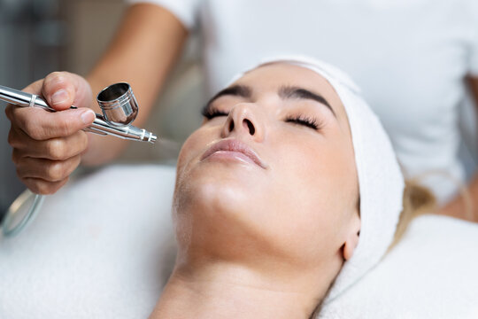 Oxygen facial Vienna VA treatment with esthetician using airbrush device to apply oxygen serum on client’s face