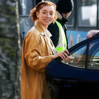 Woman wearing a tan leather coat opening a car door with a casual street style look